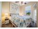 Bright bedroom with stylish bedding, complemented by natural light and a contemporary ceiling fan at 13238 Chipout Ln, Hudson, FL 34669