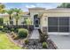 Inviting home entrance with well-kept landscaping and a screened garage at 13238 Chipout Ln, Hudson, FL 34669