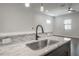 Elegant kitchen island with marble countertop, modern faucet, and view into living area at 1330 W Gray St # 1, Tampa, FL 33606