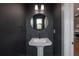 Stylish powder room with a sleek pedestal sink and dark accent wall at 1330 W Gray St # 1, Tampa, FL 33606