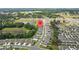 Aerial view of a residential neighborhood with a pond, showcasing community layout at 13686 Whiskey Daisy Dr, Dade City, FL 33525