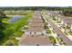 An aerial view showcases homes near a pond, highlighting neighborhood with manicured lawns at 13686 Whiskey Daisy Dr, Dade City, FL 33525