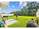 Spacious backyard features a well-maintained lawn, grill, and patio at 13686 Whiskey Daisy Dr, Dade City, FL 33525