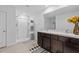 Bright bathroom featuring double sinks, dark wood cabinets, and tiled flooring at 13686 Whiskey Daisy Dr, Dade City, FL 33525