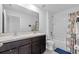 Modern bathroom featuring double sinks, dark wood cabinets, and shower-tub combo at 13686 Whiskey Daisy Dr, Dade City, FL 33525