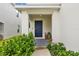 Inviting front entrance with a blue door, tidy landscaping, and a covered porch at 13686 Whiskey Daisy Dr, Dade City, FL 33525