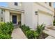 Inviting front entrance with a blue door, tidy landscaping, and a covered porch at 13686 Whiskey Daisy Dr, Dade City, FL 33525