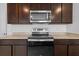 Kitchen featuring stainless steel appliances and ample dark wood cabinet space at 13686 Whiskey Daisy Dr, Dade City, FL 33525