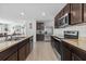 Modern kitchen with stainless steel appliances, dark wood cabinets, and a breakfast bar at 13686 Whiskey Daisy Dr, Dade City, FL 33525