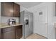 Kitchen area with stainless steel fridge, dark wood cabinets, and light countertops at 13686 Whiskey Daisy Dr, Dade City, FL 33525
