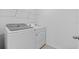 Laundry room features modern, white washer and dryer units, plus wire shelving at 13686 Whiskey Daisy Dr, Dade City, FL 33525