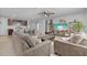Bright living room with ceiling fan, two couches and open access to the kitchen with breakfast bar at 13686 Whiskey Daisy Dr, Dade City, FL 33525