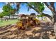 A wooden playground structure with slides and climbing features provides a fun space for  at 13686 Whiskey Daisy Dr, Dade City, FL 33525