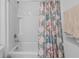 Bright bathroom with a tiled shower and tub combination with floral curtain at 13686 Whiskey Daisy Dr, Dade City, FL 33525