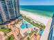Stunning aerial view of a condo's pool area, beach access, and ocean vistas at 1520 Gulf Blvd # 1505, Clearwater Beach, FL 33767