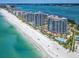 Breathtaking aerial view of beachfront condo community with pools, lush landscaping, and direct beach access at 1520 Gulf Blvd # 1505, Clearwater Beach, FL 33767