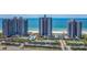 Aerial view of oceanfront condos with swimming pool, tennis courts, and mature palm trees at 1520 Gulf Blvd # 1505, Clearwater Beach, FL 33767