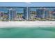 Aerial view showcases beachfront condos with stunning water views, pools, and lush landscaping along the shore at 1520 Gulf Blvd # 1505, Clearwater Beach, FL 33767