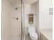 Bathroom featuring a separate walk-in shower with glass door and tiled surround, next to the toilet with matching tile at 1520 Gulf Blvd # 1505, Clearwater Beach, FL 33767