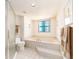 Bright bathroom features a large soaking tub with tile surround and shower with glass door, plus a view from the window at 1520 Gulf Blvd # 1505, Clearwater Beach, FL 33767