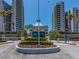 Community entrance with manicured flower bed, mature palm trees, and gated security at 1520 Gulf Blvd # 1505, Clearwater Beach, FL 33767