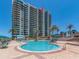 High-rise condo building exterior with a swimming pool in front, blending luxury living with outdoor enjoyment at 1520 Gulf Blvd # 1505, Clearwater Beach, FL 33767
