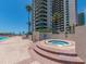 Inviting hot tub near high-rise building, framed by brick and palm trees, offering relaxation and scenic views at 1520 Gulf Blvd # 1505, Clearwater Beach, FL 33767