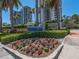Community signage with mature landscaping, flowers, and palm trees at 1520 Gulf Blvd # 1505, Clearwater Beach, FL 33767