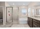 Bathroom with a glass shower, soaker tub, and double vanity with granite countertops at 1675 Bering Rd, Wesley Chapel, FL 33543