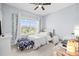 Bright bedroom featuring a ceiling fan, large window, and carpeted floors at 1675 Bering Rd, Wesley Chapel, FL 33543
