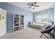 Bedroom with blue walls, a large window, and a bookshelf for storage at 1675 Bering Rd, Wesley Chapel, FL 33543