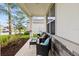 Seating area on a covered front porch that has a stone accent wall at 1675 Bering Rd, Wesley Chapel, FL 33543
