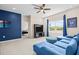 Living room with a large blue couch, a wall-mounted tv, and a view to the outdoors at 1675 Bering Rd, Wesley Chapel, FL 33543
