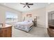 Main bedroom with a large window, upholstered headboard and a leather sofa at 1675 Bering Rd, Wesley Chapel, FL 33543