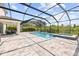 Beautiful screened-in pool area with spa, lush landscaping, and spacious patio at 1675 Bering Rd, Wesley Chapel, FL 33543