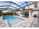 Enclosed pool area with a large pool, an outdoor kitchen, and patio furniture at 1675 Bering Rd, Wesley Chapel, FL 33543