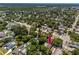 An aerial view of a quaint home with a swimming pool surrounded by lush green landscape at 1683 Pine St, Largo, FL 33774