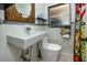 A minimalist bathroom features a floating sink and toilet against textured white walls at 1683 Pine St, Largo, FL 33774