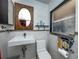 Bright and minimalist bathroom featuring floating sink, toilet, wood framed mirror, and a small window at 1683 Pine St, Largo, FL 33774