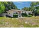 Single-story home with manicured front yard, hedge landscaping and flag at 1683 Pine St, Largo, FL 33774