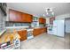 Traditional kitchen with wooden cabinets, white appliances, and tiled flooring at 1683 Pine St, Largo, FL 33774