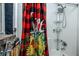 Bright shower with red-patterned curtain, updated shower head, and shelving unit at 1683 Pine St, Largo, FL 33774