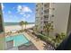 Condo view of pool, beach, and palm trees offers a relaxing and picturesque tropical escape at 17710 Gulf Blvd # 304, Redington Shores, FL 33708