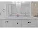 Bright bathroom with a double sink vanity, marble countertops, modern fixtures, and two large framed mirrors at 17710 Gulf Blvd # 304, Redington Shores, FL 33708