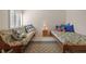 Comfortable bedroom features two twin beds, a patterned rug, and ample natural light from the window at 17710 Gulf Blvd # 304, Redington Shores, FL 33708