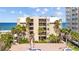 Exterior view of the building with balconies and palm trees, offering stunning ocean views at 17710 Gulf Blvd # 304, Redington Shores, FL 33708