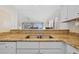 Kitchen featuring granite countertops, stainless steel sink, and access to the living area at 17710 Gulf Blvd # 304, Redington Shores, FL 33708