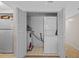 Enclosed laundry area features a stacked washer and dryer unit next to a refrigerator and water heater at 17710 Gulf Blvd # 304, Redington Shores, FL 33708