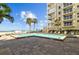 Inviting outdoor pool with lounge chairs, palm trees, and beach access for residents to enjoy at 17710 Gulf Blvd # 304, Redington Shores, FL 33708
