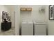 Functional laundry room with a washer, dryer, and storage shelves, offering convenience and organization at 18154 Serene Lake Loop, Lutz, FL 33548